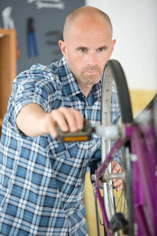 man checking the bikes wheel alignment