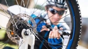 Male Cyclist Inflating Tire Of Bicycle