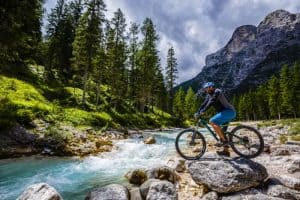 Tourist cycling in Cortina d'Ampezzo, stunning rocky mountains o